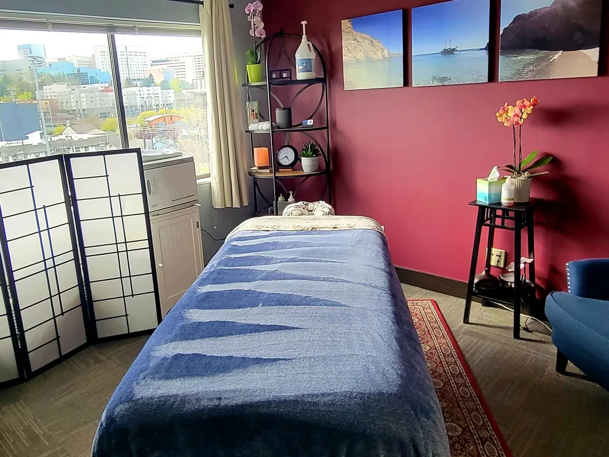 Atlas Chiropractic treatment room with a massage table and a window onto the Seattle skyline